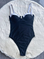 Black push-up swimwear by 64b136-1e, available as a 2-piece or one-piece bathing suit, featuring supportive design and stylish fit.