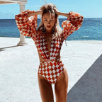 Woman wearing a 64b136-1e one-piece sleeved swimsuit, black swimwear with long sleeves, suitable for swimming and sun protection.