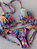 Boho tassel bottom bikinis with colorful prints, stylish swimwear from 64b136-1e displayed on a model in a tropical setting.