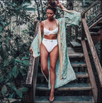 Boho chic turquoise kimono outerwear with flowing fabric and intricate patterns, worn open over casual outfits.