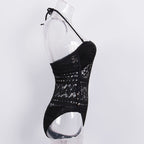 Black one-piece hollow swimsuit by 64b136-1e, featuring cut-out details and sleek swimwear design, shown on a model.