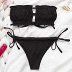 Black bandeau string bikini swimwear by 64b136-1e, featuring minimal coverage and classic design, perfect for beach or pool.