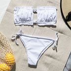 Black bandeau string bikini swimwear by 64b136-1e, featuring a sleek strapless design and minimal coverage for beachwear.